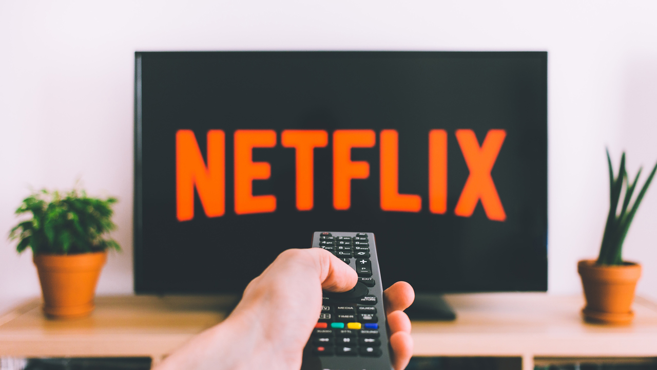 A person operating a television showing the Netflix logo