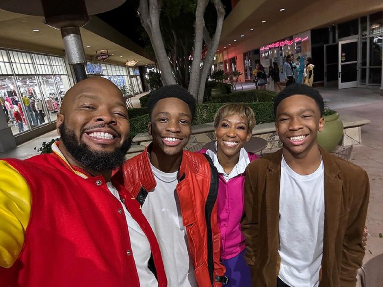 Kev On Stage taking a selfie with Isaiah, Melissa, and Josiah Fredericks near Old Navy at nighttime