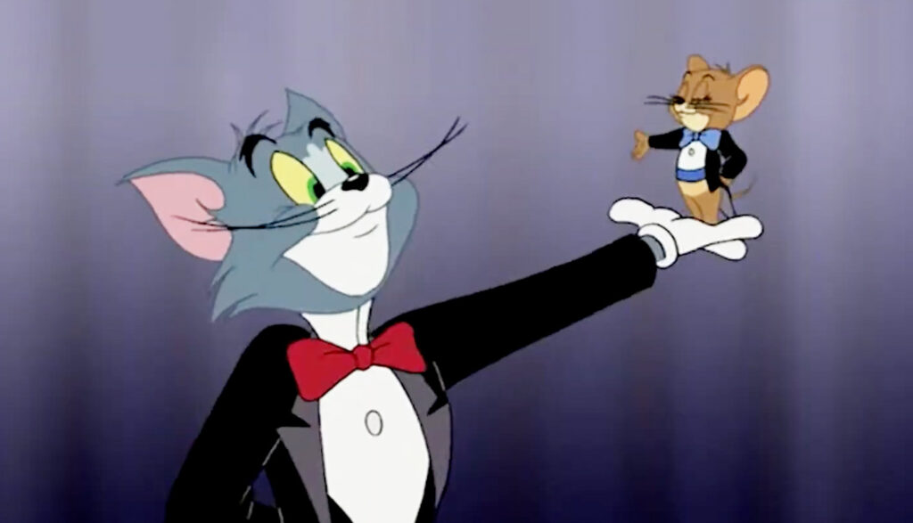 Tom wearing a black coat while holding Jerry on his hand