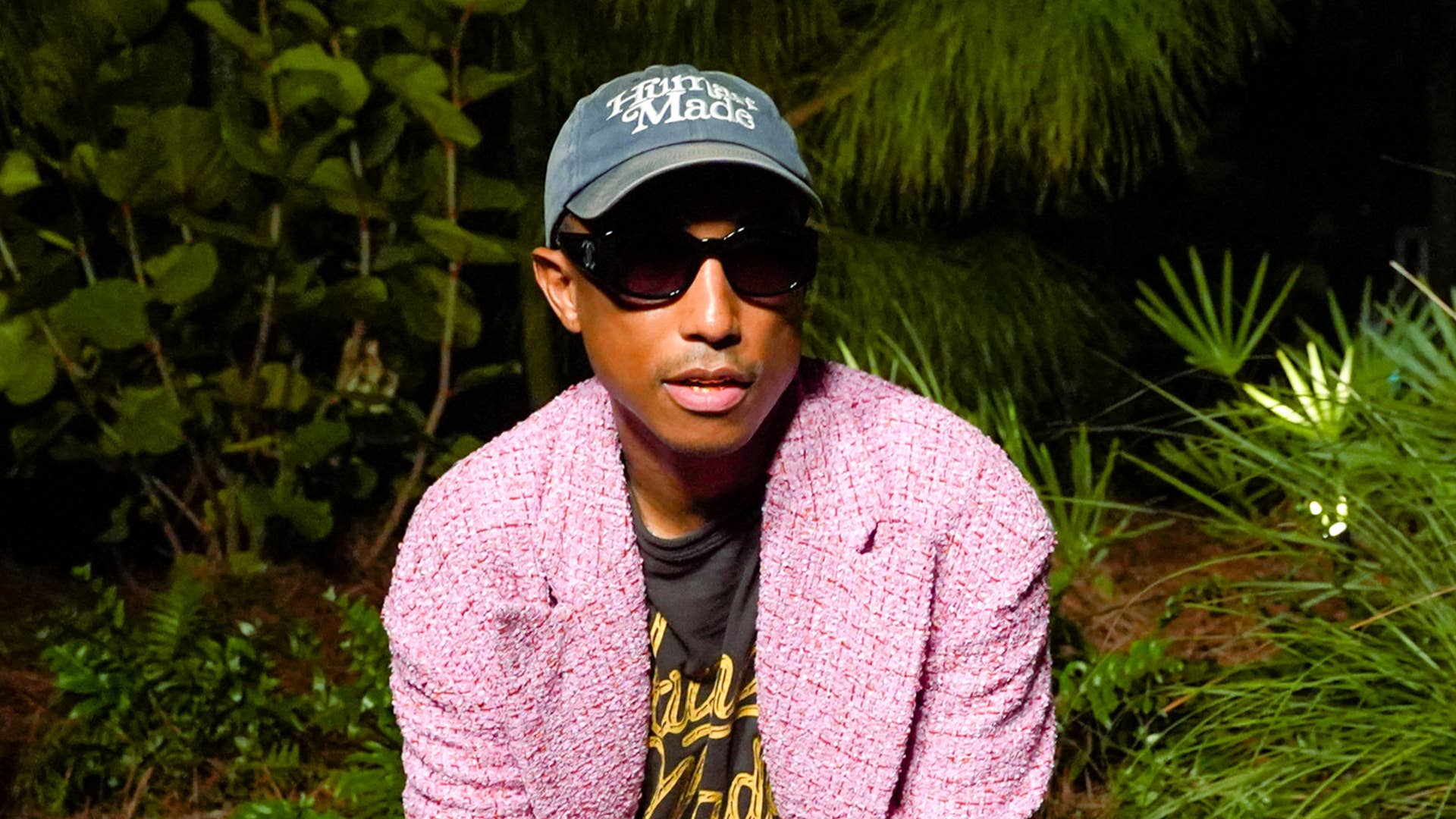 Pharrell Williams wearing a pink jacket and sunglasses