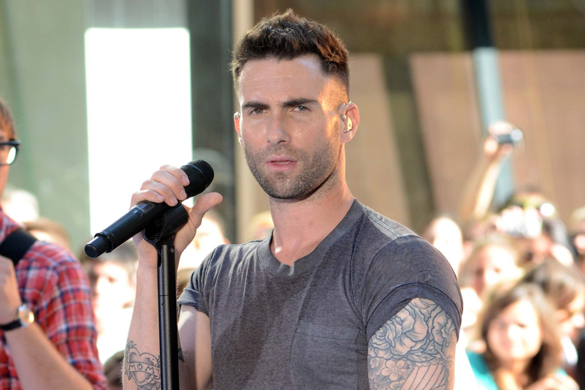 Adam levine wearing a gray shirt with mic in front