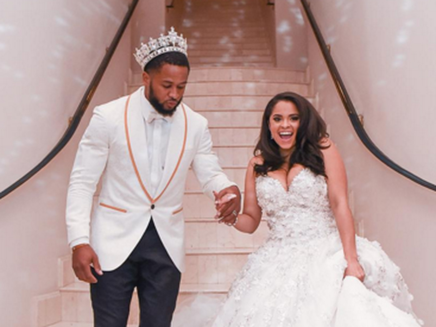 Earl Thomas wearing a white suit and Nina Heisser wearing a white weddng gown