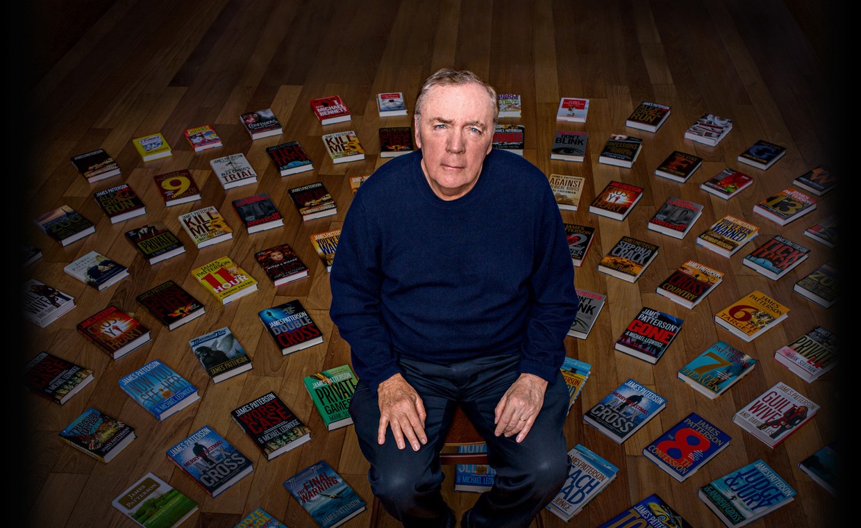 James Patterson wearing a blue sweater with his books