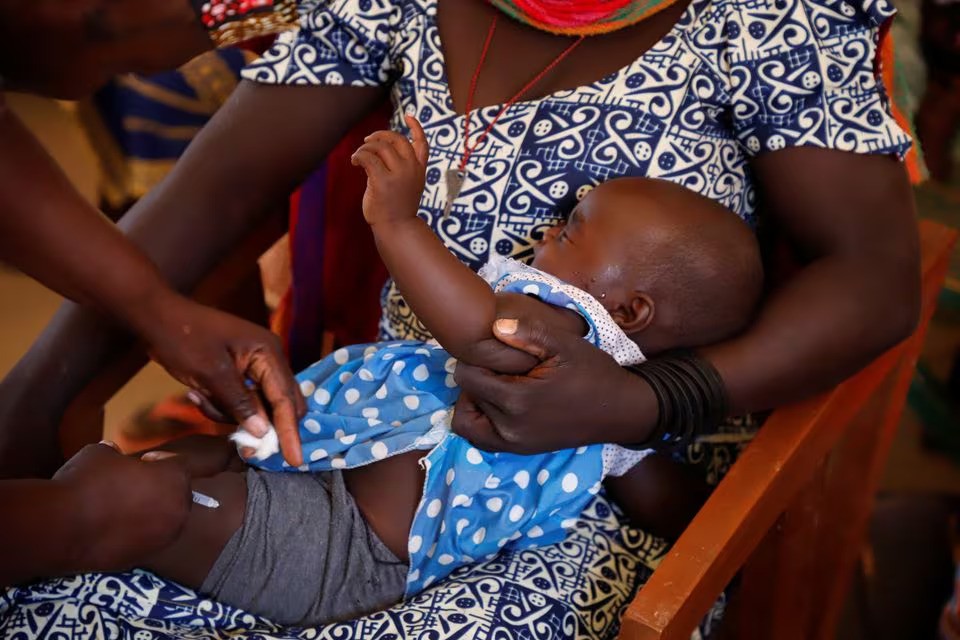 A nurse administers a malaria vaccine to an infant at the health center in Datcheka