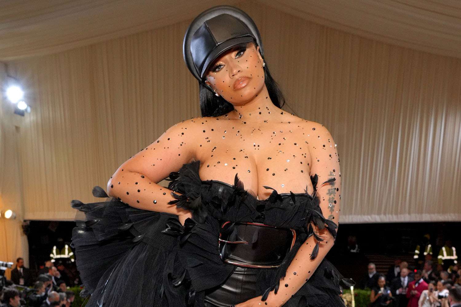 Nicki Minaj wearing a black dress and cap