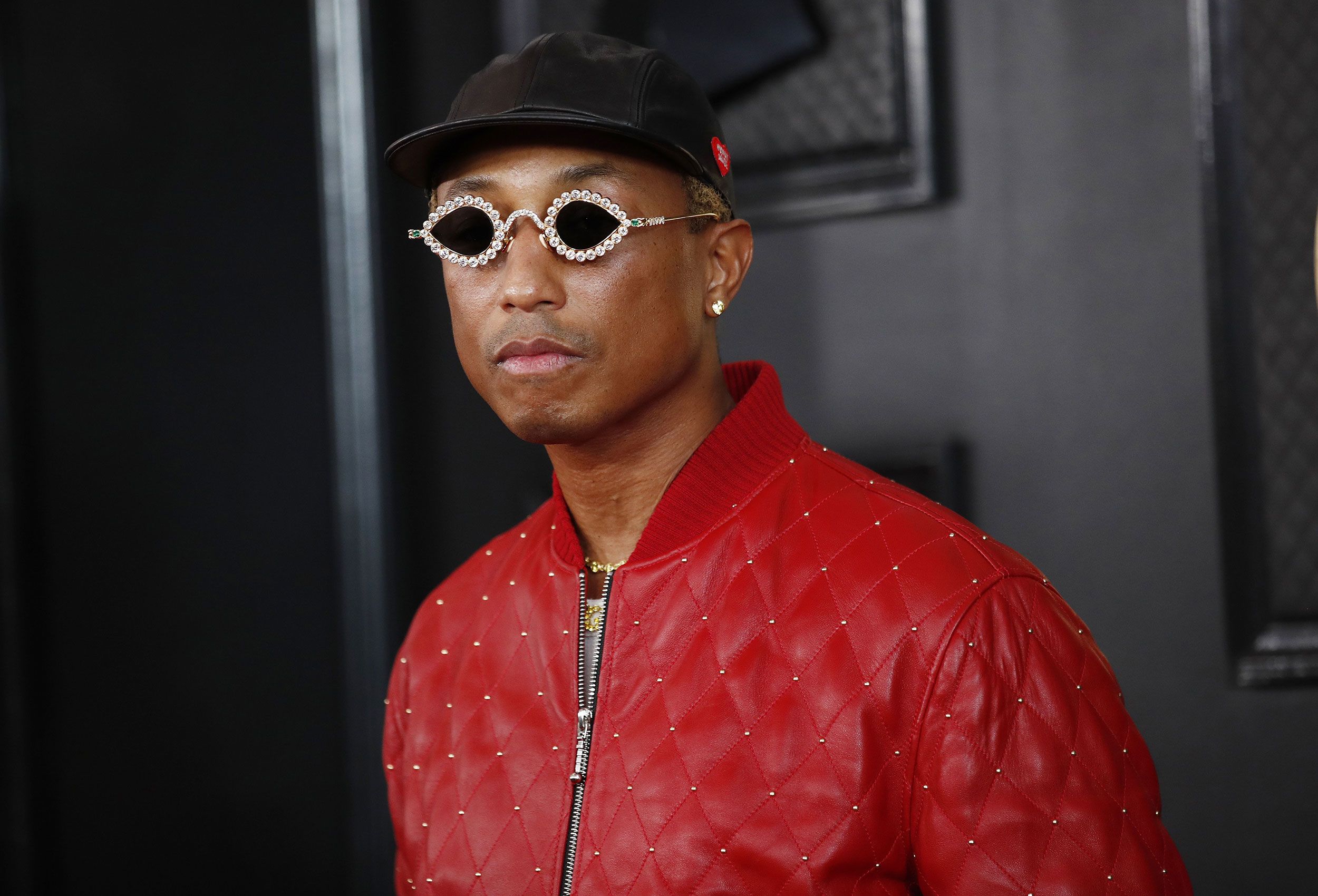 Pharrell Williams wearing a red jacket and sunglasses