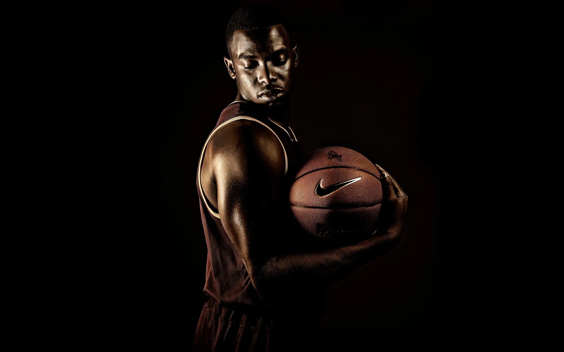 A man wearing a basketball uniform while holding a basketball