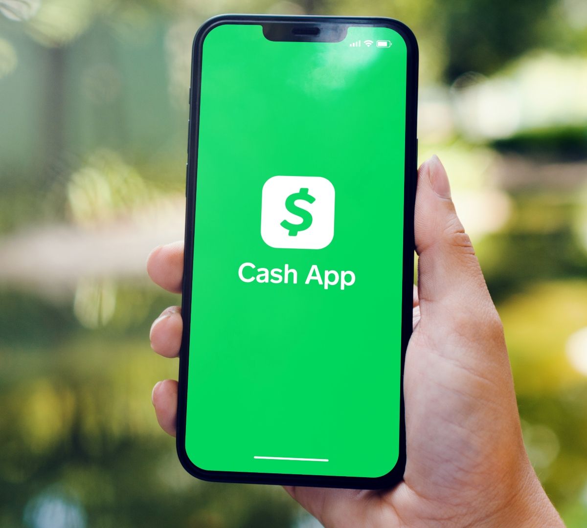 A person's holding a phone, and screen displaying cash app