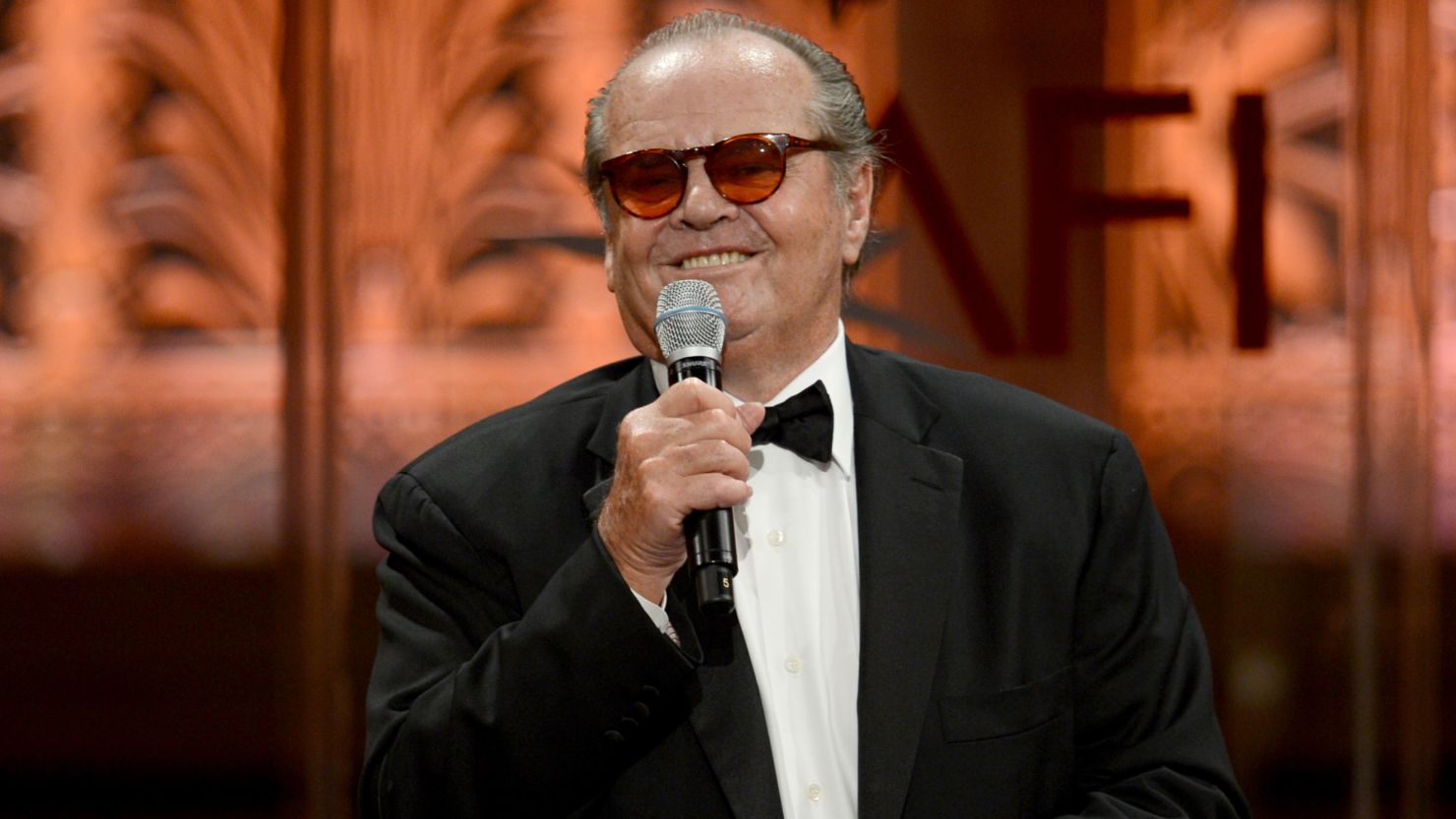 Jack Nicholson wearing a black suit and mic