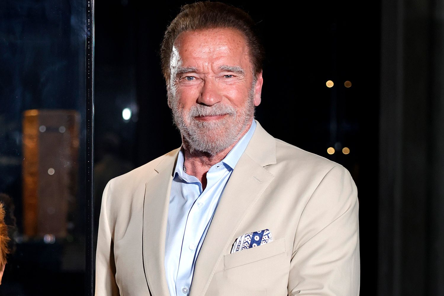 Arnold Schwarzenegger wearing a beige suit