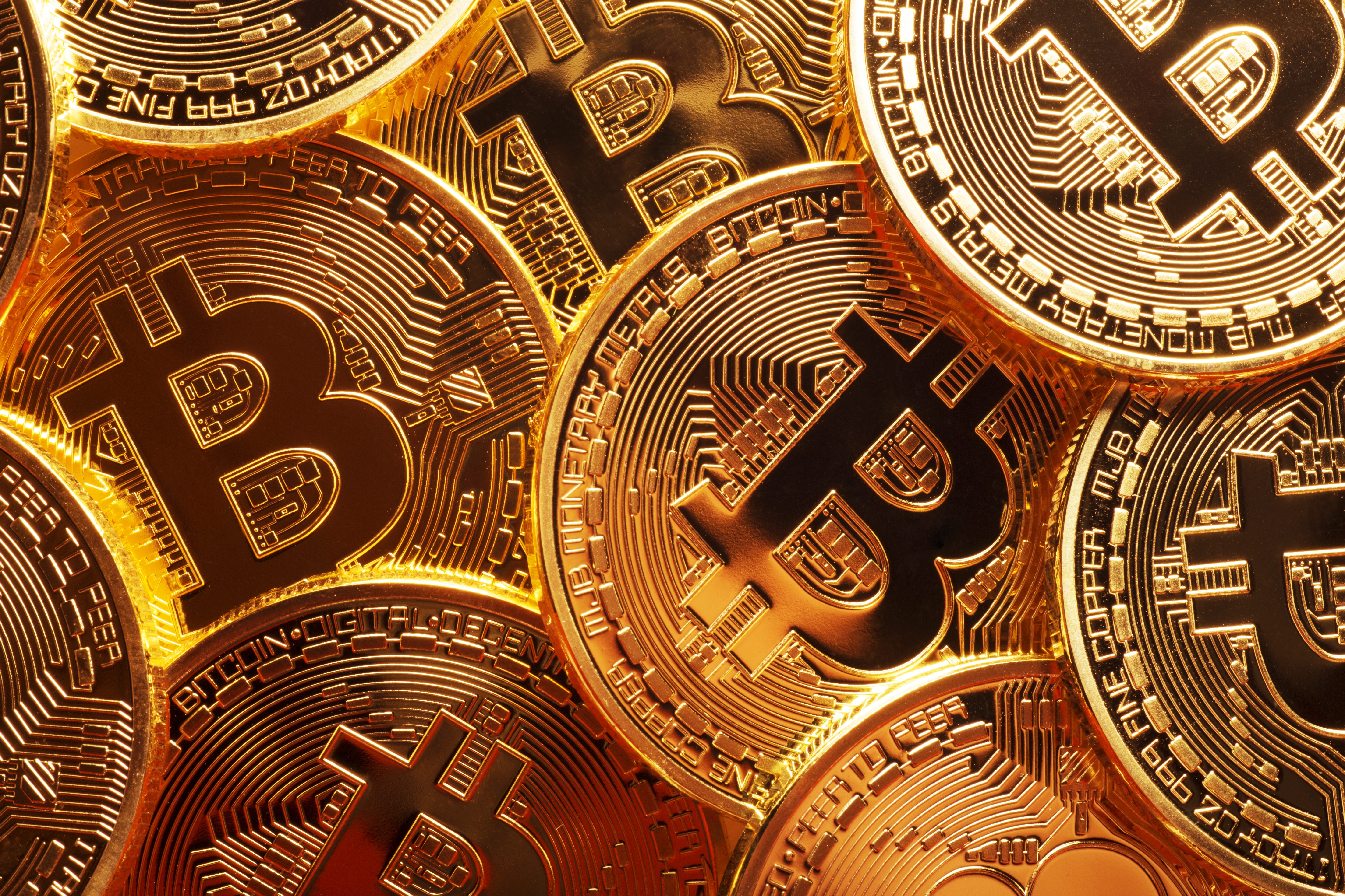 A pile of gold-colored coins with the word "Bitcoin" on them