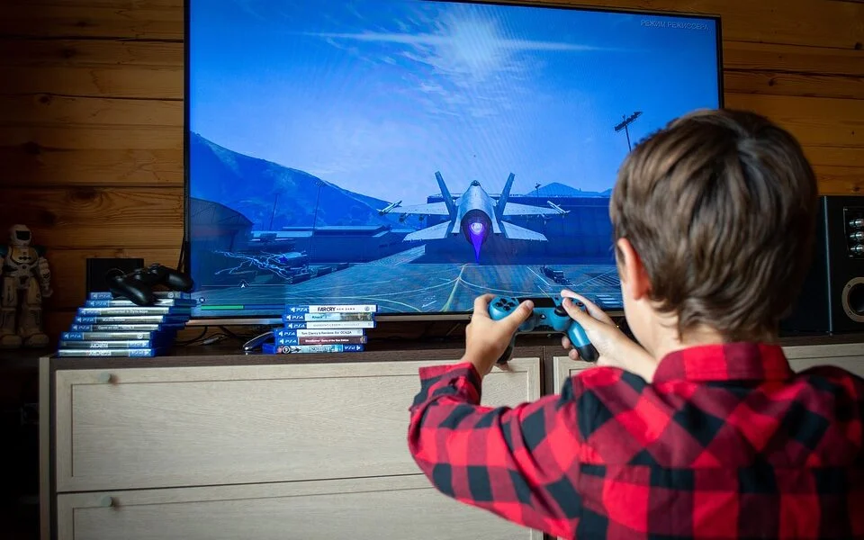 A boy is playing online game on TV screen.