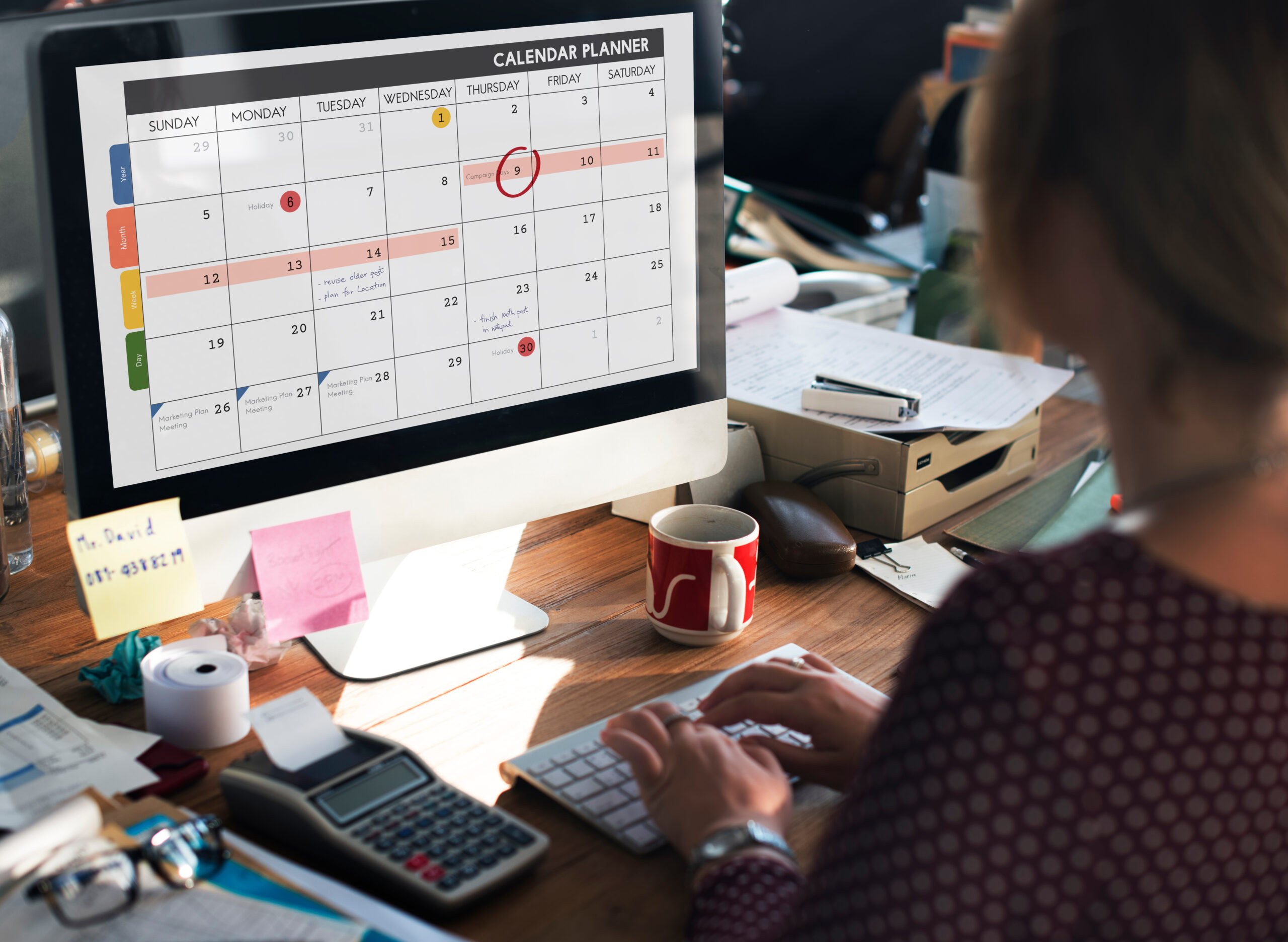 A woman marking dates on a calendar app on her desktop computer