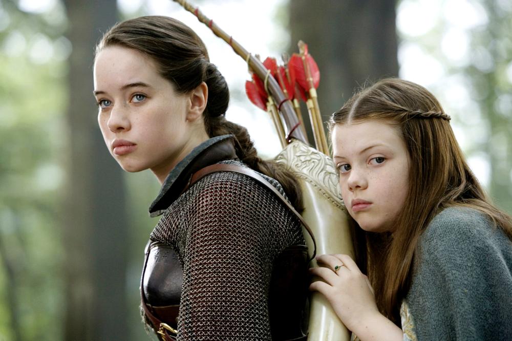 Anna Popplewell as Susan Pevensie on a horse and bows with a girl