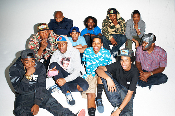 A group of black men in caps, hoodies, and sneakers posing for photo