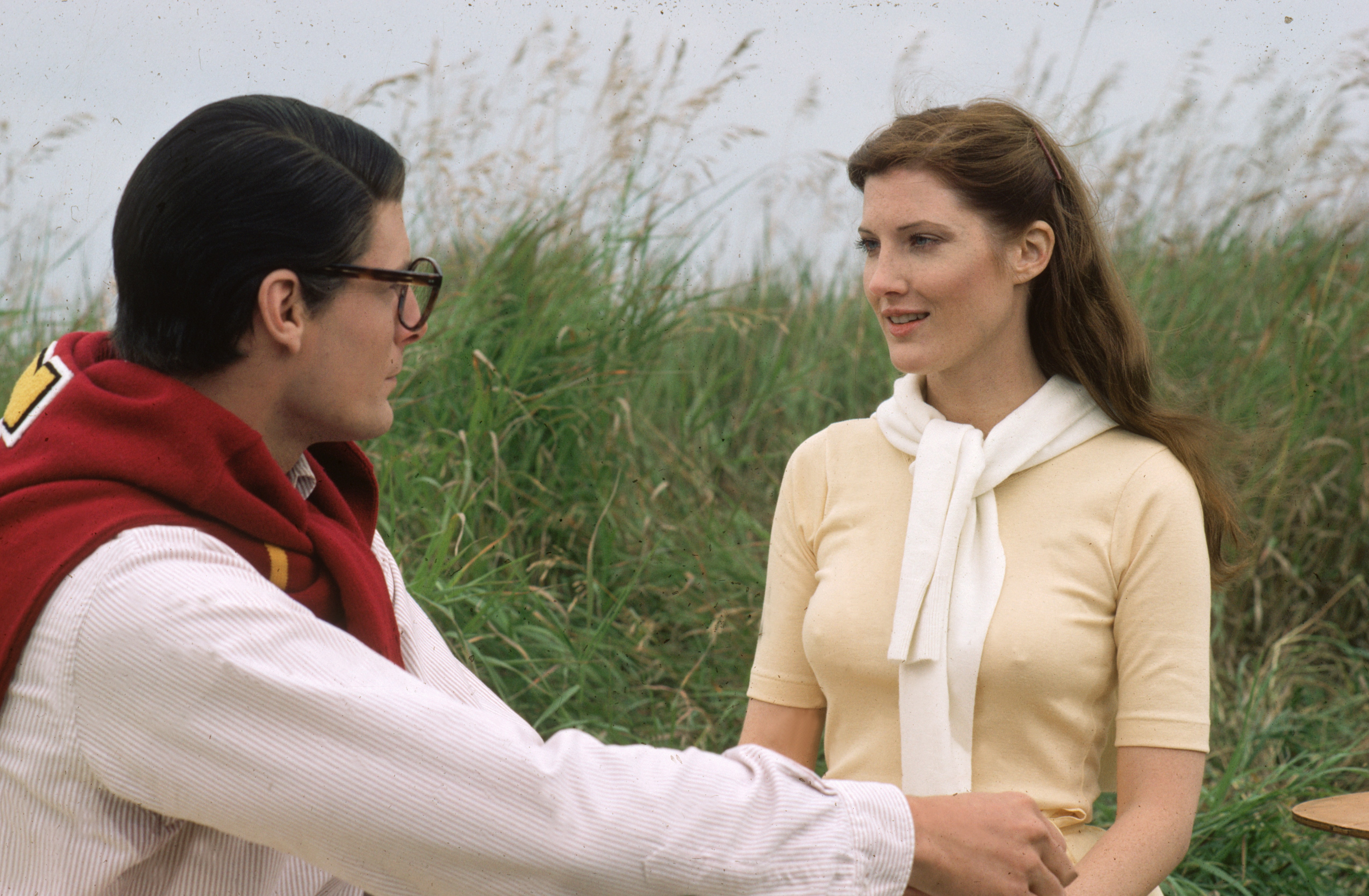 Annette O'Toole in a light brown dress alongside Christopher Reeve with a cardigan around his neck in Superman III
