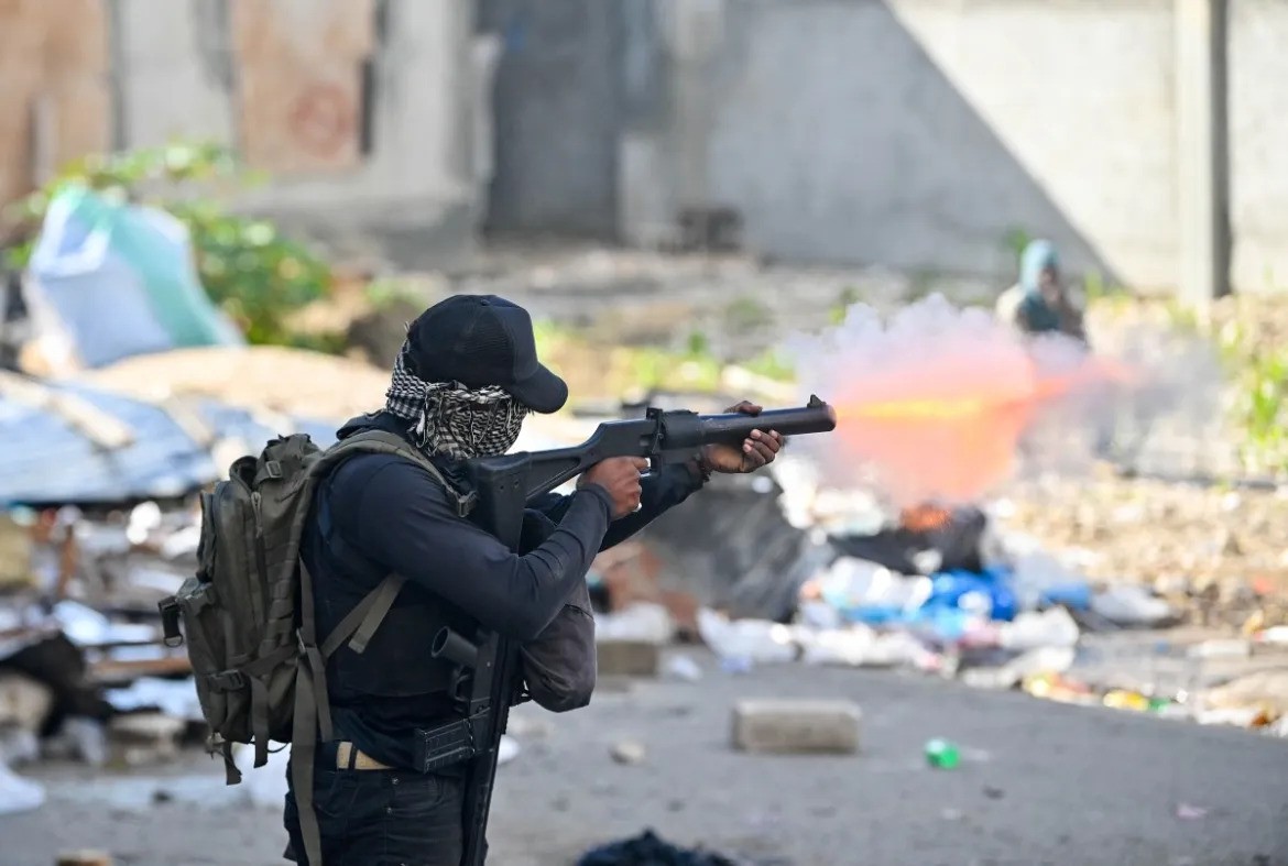 A policeman fires tear gas at protesters