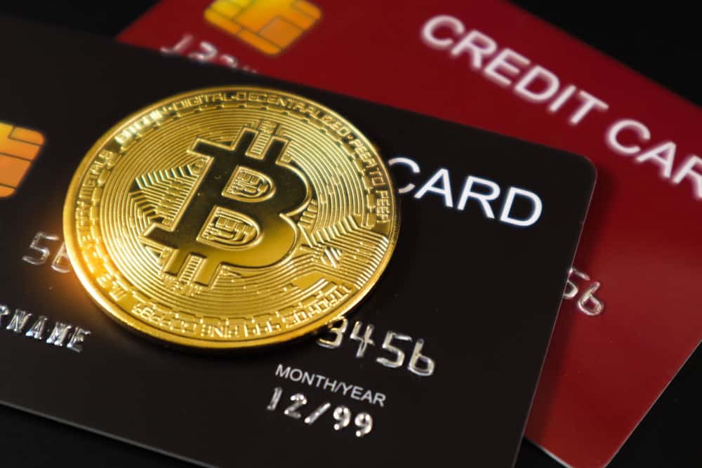 A bitcoin on top of two credit cards