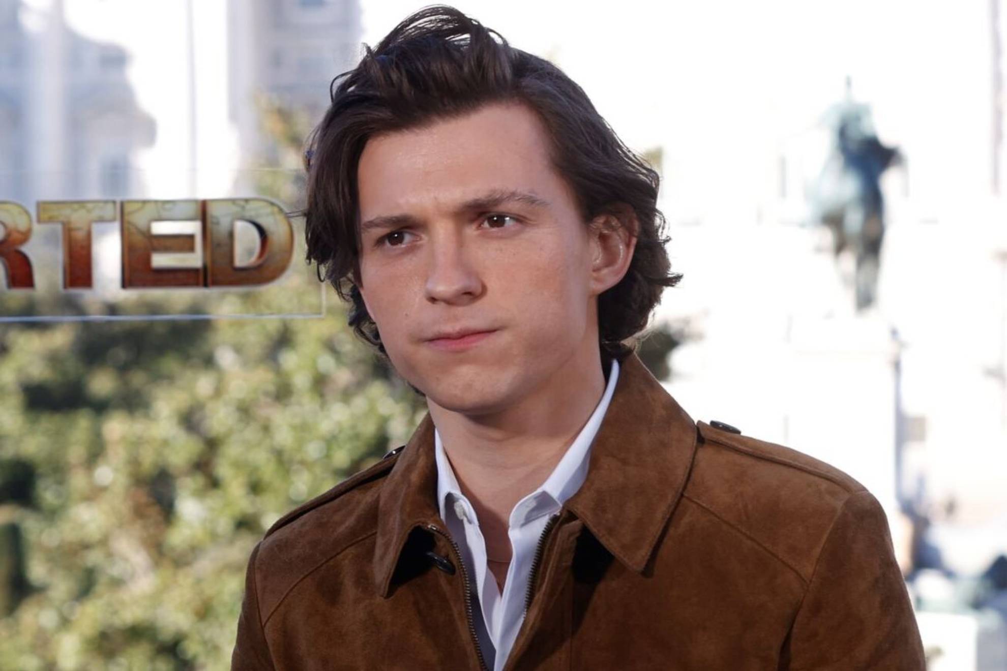 Tom Holland wearing a brown jacket