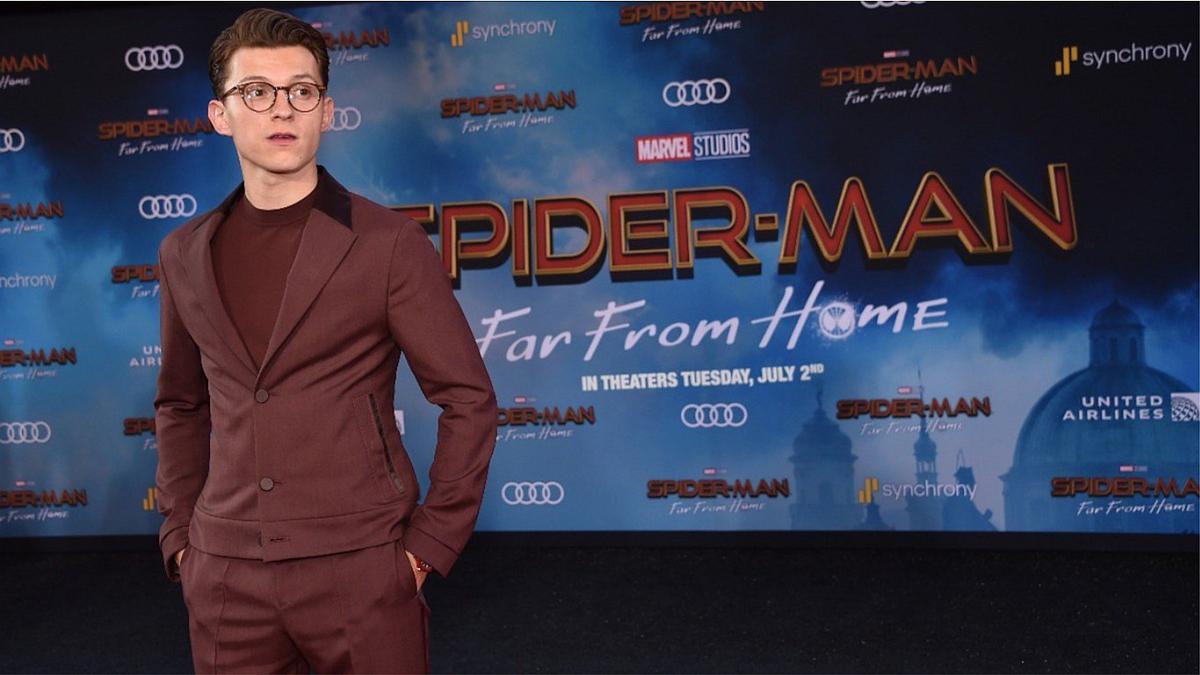 Tom Holland wearing a maroon suit