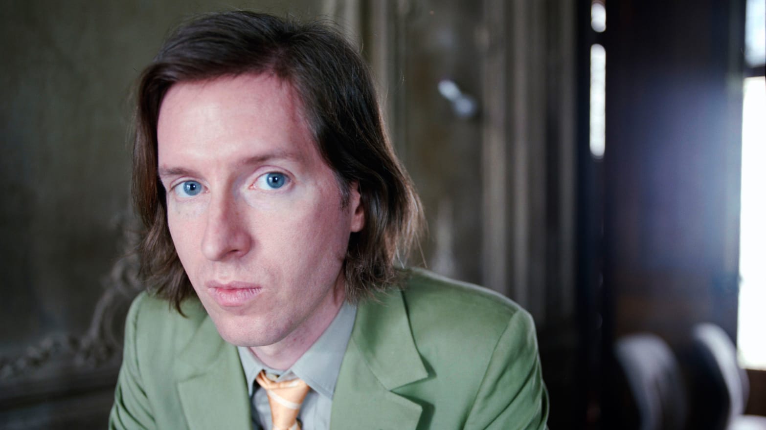 Wes Anderson wearing a green suit