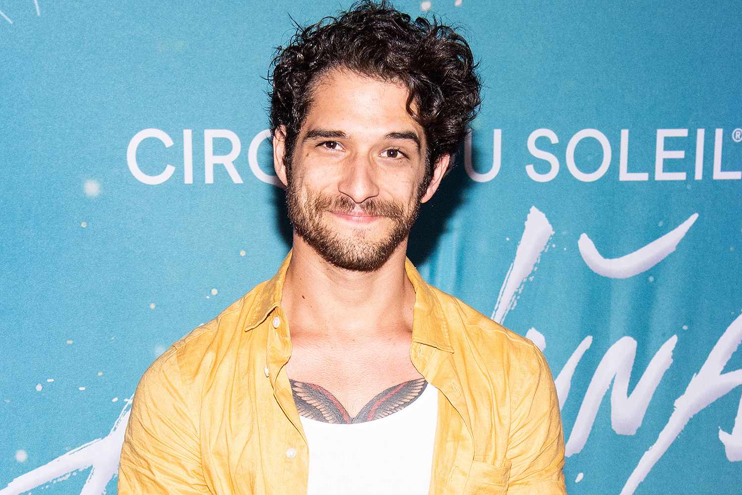 Tyler Posey wearing a yellow shirt at an event