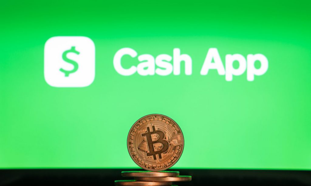 Stack of bitcoin placed in front of screen displaying cash app